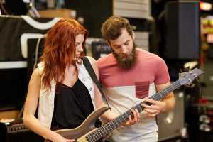 adult guitar student and teacher in studio