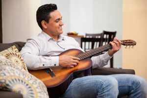 man playing guitar at home 