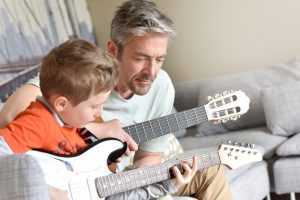 father and son learning guitar together