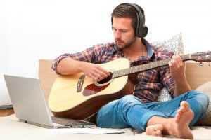 adult man practicing guitar