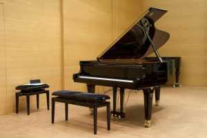 grand piano on stage with bench