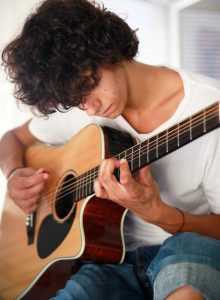 young man practicng guitar